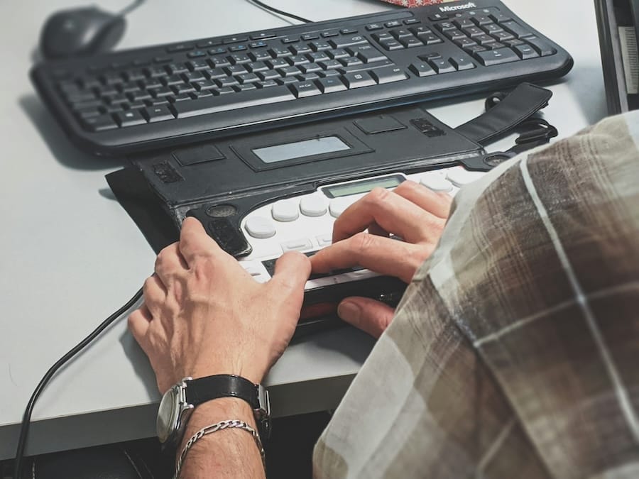 Person vor einer Tastatur und einem Screenreader